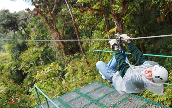 Guy ziplining in jungle